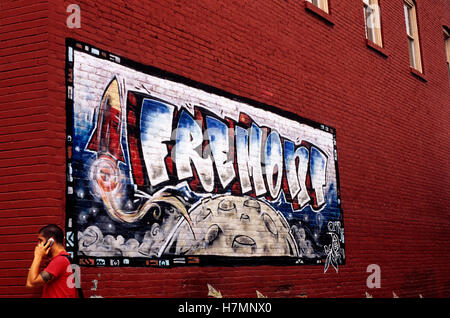 El solsticio de verano el hombre justo en el teléfono con el mural en el edificio de ladrillos rojos, humor, distrito de Fremont, Seattle, Washington EE.UU. Foto de stock