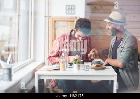 Una pareja gay sat manos en cafe