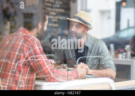 Una pareja gay sat manos en cafe