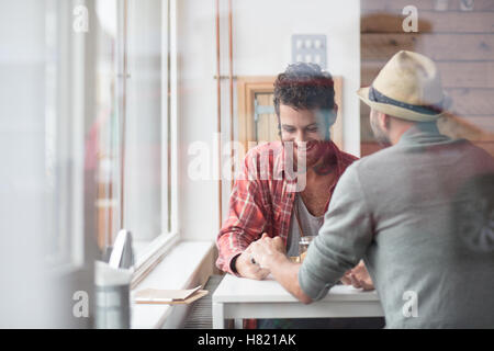 Una pareja gay sat manos en cafe