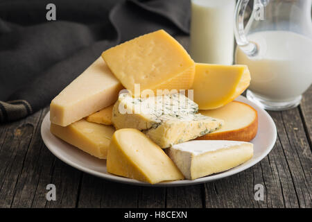 Diferentes tipos de quesos en la mesa de madera antigua.