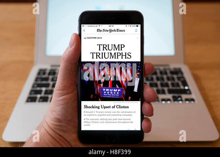 Detalle de iPhone Teléfono Inteligente móvil En línea mostrando la primera página del periódico titular del New York Times después de Donald Trum