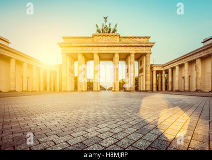 Vista clásica de la famosa Puerta de Brandenburgo en dorado al amanecer, la luz de la mañana en el centro de Berlín, Alemania Foto de stock
