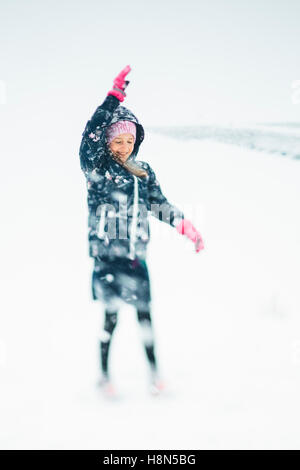 Chica (10-11) jugando en la nieve Foto de stock