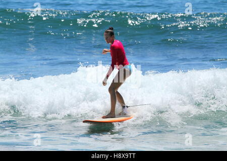 Una mujer de treinta años surf longboard en Moffat Beach en la Sunshine Coast de Queensland, Australia. Foto de stock