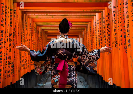 KYOTO, Japón - Octubre 8, 2016: la mujer no identificada en la pasarela en el santuario Fushimi Inari en Kioto, Japón. Este popular santuario han Foto de stock