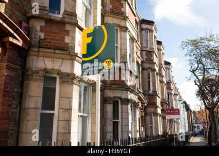 Inmobiliaria los signos externos de una hilera de casas adosadas victorianas en una calle de Londres, Inglaterra, Reino Unido.