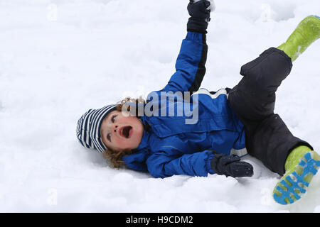 Joven jugando y rodar en la nieve Foto de stock