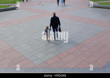 Padre e hijo cogidos de la mano en un paisaje urbano moderno gráfico urbano Foto de stock