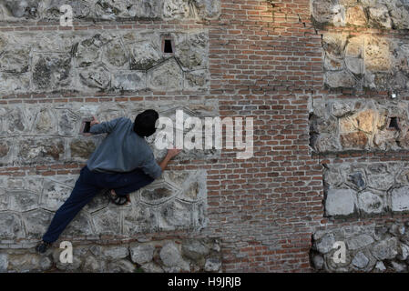 Madrid, España. 23 Nov, 2016. Un hombre sube una pared en la Cuesta de la Vega street, en el centro de la ciudad de Madrid, España. © Jorge Sanz/Pacific Press/Alamy Live News