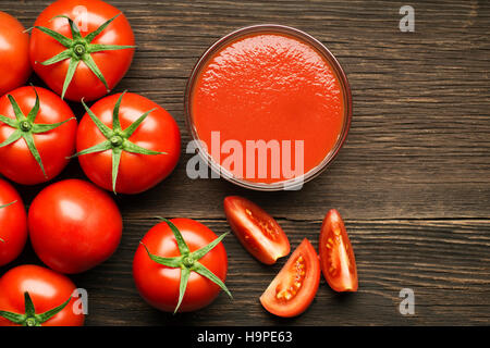 Salsa de tomate cherry fresco sobre fondo de madera rústica Foto de stock