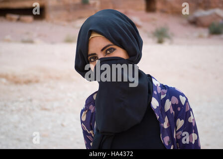 Cerca de un Beduino chica con cara oculta detrás del velo posando en cámara Foto de stock