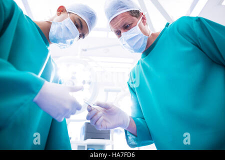 Los cirujanos que realizan la operación en sala de operaciones Foto de stock