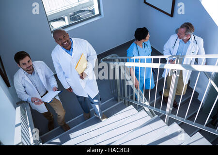 Retrato de los médicos interactuar unos con otros, mientras que subir escaleras Foto de stock
