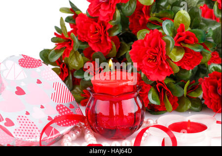 Las flores rojas, velas y caja de regalo de cerca la imagen. Foto de stock