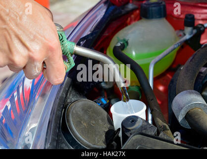 Joven llenar el depósito de líquido limpiaparabrisas de un coche Fotografía  de stock - Alamy