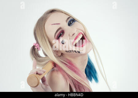 Chica en traje de Harley Quinn. Ella se levanta con un bate y lame el bat.  Cerca. Cosplay Fotografía de stock - Alamy