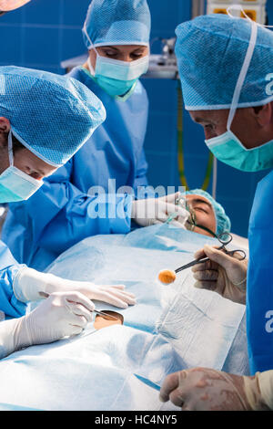 Los cirujanos que realizan la operación en sala de operaciones Foto de stock