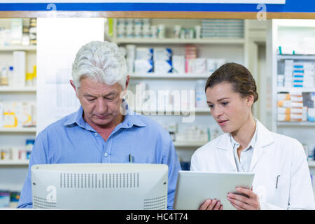 Los farmacéuticos mediante ordenador y tableta digital Foto de stock