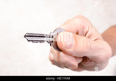 mano con llave para abrir la hucha Stock Photo