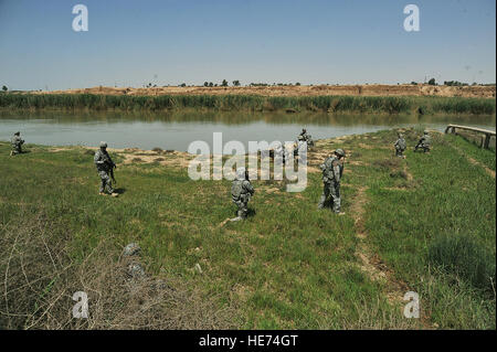 Los miembros del ejército y la fuerza aérea se tome un descanso a lo largo del río Tigris mientras realizaban una patrulla desmontada el 14 de abril de 2010, en las afueras de la base conjunta Balad, Irak. El Sargento. Quinton Russ) Foto de stock