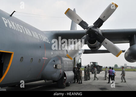 Soldados del Ejército de Nepal y el Grupo de Respuesta de contingencia 36 aviadores de descarga de suministros de un Pakistán Hercules C-130 de la Fuerza Aérea, 8 de mayo de 2015, en el Aeropuerto Internacional de Tribhuvan en Katmandú, Nepal. El ejército nepalí y aviadores trabajó con miembros militares de la Fuerza Aérea de Pakistán para procesar la carga de sus aviones que llegan a Nepal para prestar socorro en casos de desastre a raíz de un terremoto de magnitud 7,8 que asoló el país el 25 de abril. El Sargento. Melissa blanco Foto de stock