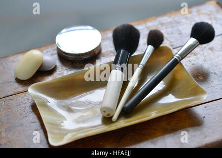 Brochas de maquillaje en un contenedor de la bocina, cuartos de baño de lujo. Foto de stock