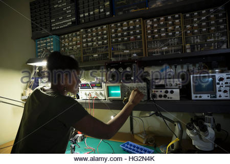 Ingeniero de mujeres trabajando en equipos electrónicos de taller
