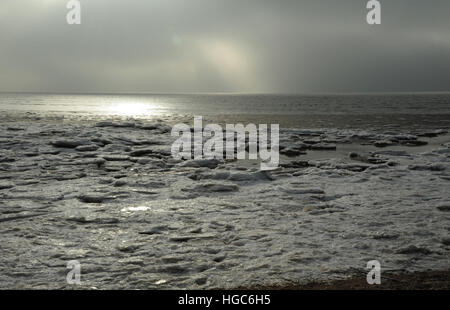 Nubes grises ver extensión blanca tierra-mar hielo rápido hacia la calma se aleja del mar, de la playa al este de St Annes, Fylde Coast, Lancashire Foto de stock