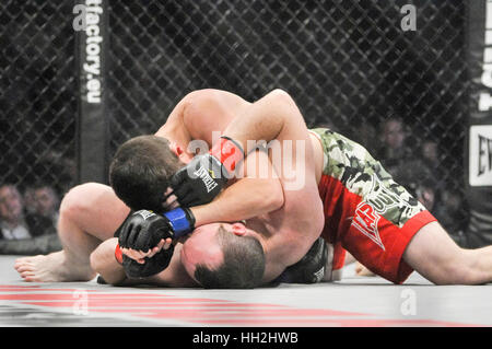 Dos fighers jaula MMA en el ring luchando sobre el piso. Foto de stock