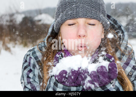 Mujer bonita joven en ropa de invierno y guantes con nieve