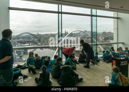 Los escolares disfrutando de la vista del cuadro de visualización en la 4ª planta del centro báltico de arte contemporáneo en Gateshead.
