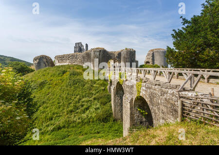 Puente entrada que conduce a la cima de la colina de ruinas de castillo Corfe, sobreviviente de la guerra civil inglesa, en Corfe, en Dorset, en el suroeste de Inglaterra en un día soleado Foto de stock