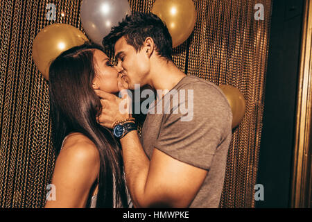 Disparo de romántico joven pareja besándose en el club nocturno. El hombre y la mujer en el pub. Foto de stock