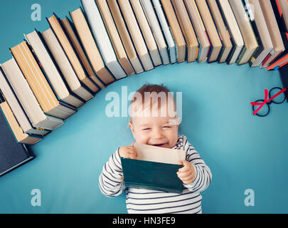 Bebé de Un año de edad con spectackles y libros