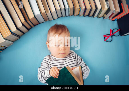 Bebé de Un año de edad con spectackles y libros