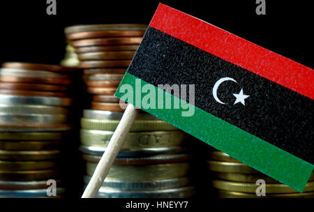 Libia ondear la bandera con la pila de dinero monedas macro Foto de stock