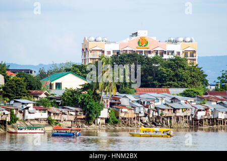 Transbordadores fluviales barrios de tugurios y viviendas a lo largo de río Bangkerohan, Davao, Davao del Sur, Filipinas Foto de stock