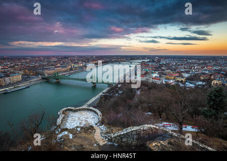 Budapest, Hungría - hermosa puesta de sol sobre la ciudad de Budapest con el río Danubio, Puente Szabadsag y baños Gellert tomada desde los pies de la colina Gellert