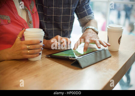 Pareja utilizando tablet digital, recortadas en la cafetería. Foto de stock