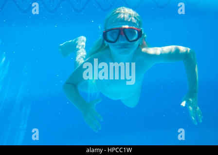 Maedchen mit Taucherbrille schwimmt Unterwasser - chica con buceo googles nadando bajo el agua.