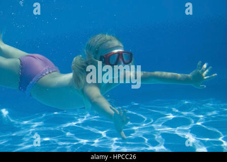 Maedchen mit Taucherbrille schwimmt Unterwasser - chica con buceo googles nadando bajo el agua.
