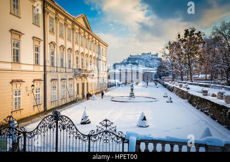 Vista clásica de los conocidos Jardines de Mirabell con la histórica fortaleza de Hohensalzburg en el fondo en luz del atardecer dorado al atardecer, Salzburgo, Austria Foto de stock