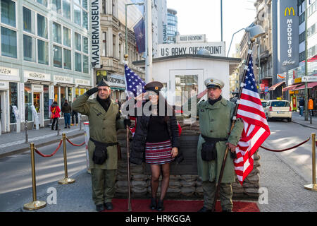 Los turistas posando con los soldados americanos en el Checkpoint Charlie, en Berlín, Alemania Foto de stock