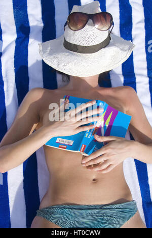 Frau mit entspannt Buch am Strand - Mujer con libro de relax en la playa Foto de stock
