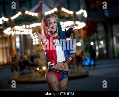 Chica en traje de Harley Quinn. Ella se levanta con un bate y lame el bat.  Cerca. Cosplay Fotografía de stock - Alamy