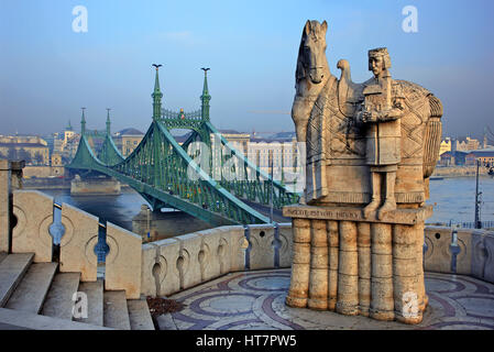 Estatua del rey - San Esteban (Szent Istvan Kiraly) y en el fondo el puente de la Libertad (Szabadság híd) sobre el río Danubio, Budapest, Hungría. Foto de stock
