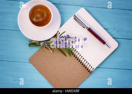 Portátil blanco, ramo de lavanda y la taza de café sobre el escritorio Foto de stock