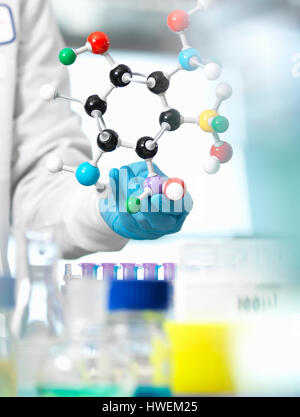 Investigador utilizando un modelo molecular para entender una fórmula química en un laboratorio Foto de stock