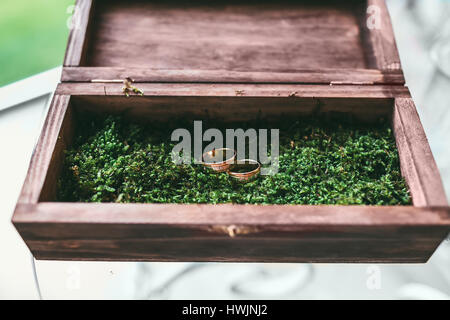 Hermosos anillos de boda de oro dentro de una caja de madera vintage Foto de stock